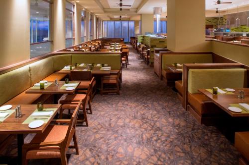 a restaurant with wooden tables and chairs and a cafeteria at Hyatt Regency Orlando International Airport Hotel in Orlando
