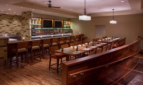 a restaurant with long tables and chairs and a bar at Hyatt Regency Orlando International Airport Hotel in Orlando