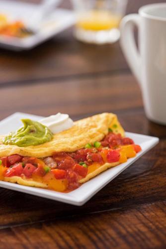 une plaque blanche avec un morceau de nourriture sur une table dans l'établissement Hyatt House Hartford North/Windsor, à Windsor