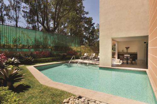 a swimming pool in the yard of a house at Hyatt Place San Jose Pinares in San José