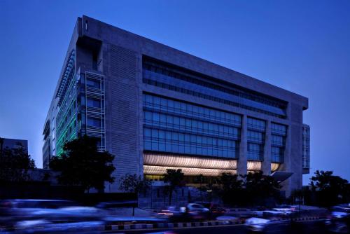 a tall building with cars parked in front of it at Park Hyatt Hotel and Residences, Hyderabad in Hyderabad