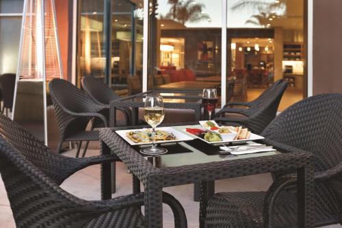 a table with a plate of food and a glass of wine at Hyatt Place at Anaheim Resort / Convention Center in Anaheim