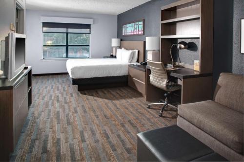 ダラスにあるHyatt House Dallas Uptownのベッドとデスクが備わるホテルルームです。