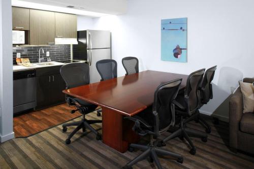 a kitchen with a wooden table and black chairs at Hyatt House Parsippany Whippany in Whippany