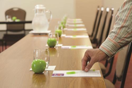 a man standing at a long table with a green apple at Hyatt Place at Anaheim Resort / Convention Center in Anaheim