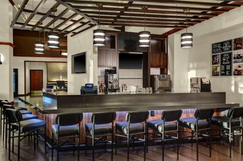 a bar in a room with a bunch of chairs at Hyatt Place Cincinnati Airport in Florence