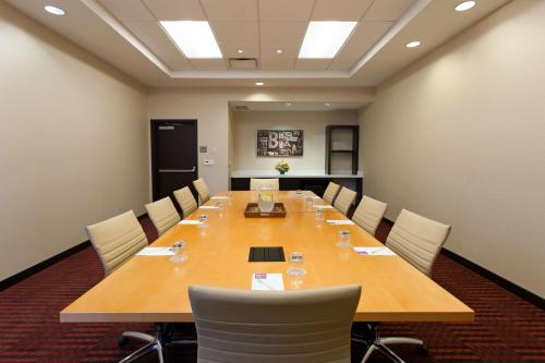 a conference room with a large wooden table and chairs at Hyatt Place Bloomington Indiana in Bloomington
