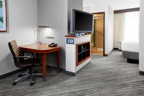 a hotel room with a desk and a television and a bed at Hyatt Place Cincinnati Airport in Florence