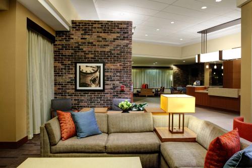 a living room with a couch and a brick wall at Hyatt Place Columbia/Downtown/The Vista in Columbia