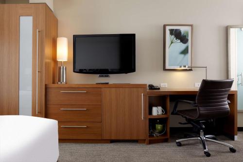 um quarto com uma secretária, uma televisão e uma cadeira em Hyatt Place Chicago-South/University Medical Center em Chicago