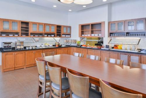 a kitchen with a table, chairs and a refrigerator at Hyatt Place Herndon Dulles Airport East in Herndon