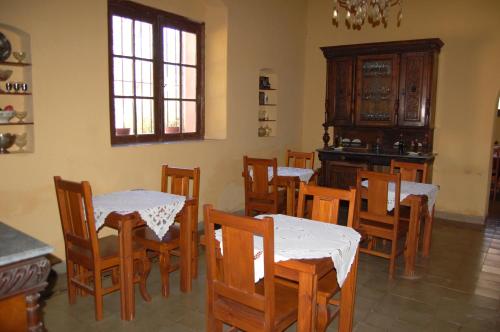 a dining room with tables and chairs and a kitchen at La Sala Hotel Boutique in Tinogasta