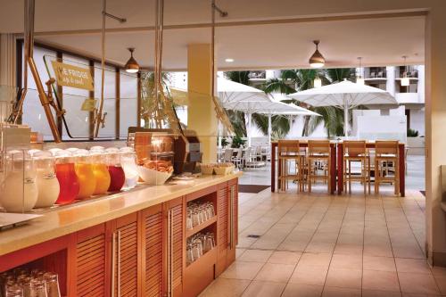 a restaurant with a counter with drinks and umbrellas at Hyatt Place Waikiki Beach in Honolulu