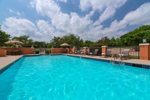 勞雷爾山的住宿－芒特勞雷爾凱悅嘉軒酒店，一个带椅子和围栏的大型蓝色游泳池