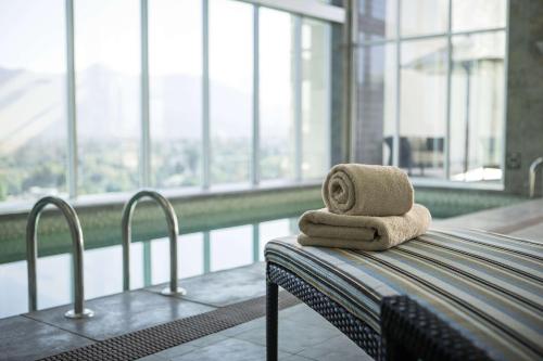 a couple of towels sitting on a table next to a pool at Hyatt Place Santiago/Vitacura in Santiago