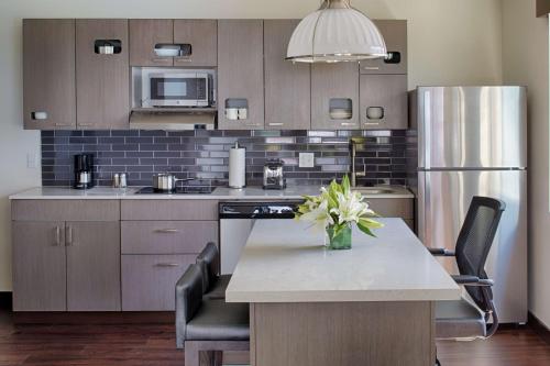 a kitchen with a table with a vase of flowers on it at Hyatt House Seattle Downtown in Seattle