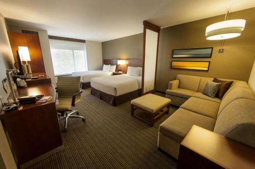 a large hotel room with a bed and a couch at Hyatt Place Tijuana in Tijuana