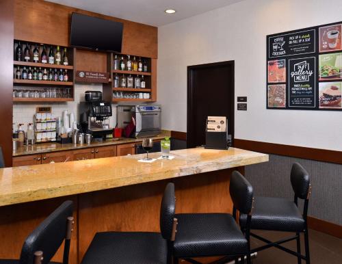 a bar in a restaurant with a counter and chairs at Hyatt Place Garden City in Garden City