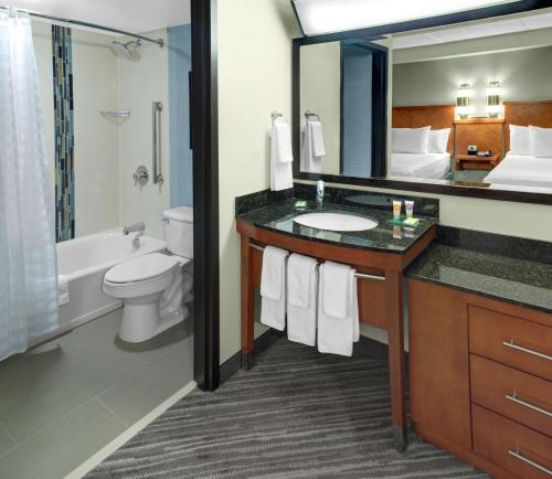 a bathroom with a sink and a toilet and a mirror at Hyatt Place Lakeland Center in Lakeland