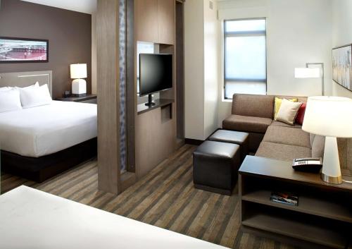 ein Hotelzimmer mit einem Bett und einem Sofa in der Unterkunft Hyatt House Pittsburgh Bloomfield Shadyside in Pittsburgh