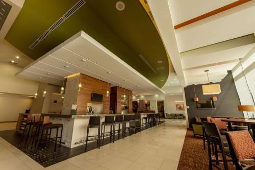 a lobby with a bar with chairs and tables at Hyatt Place Tijuana in Tijuana