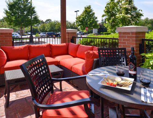 a red couch on a patio with a table and chairs at Hyatt Place Garden City in Garden City