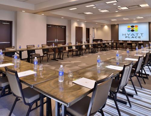 a conference room with tables and chairs with water bottles on them at Hyatt Place Garden City in Garden City