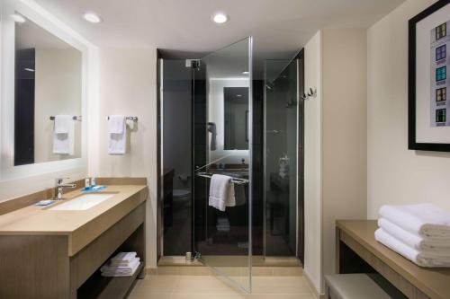 a bathroom with a glass shower and a sink at Hyatt House Charleston - Historic District in Charleston