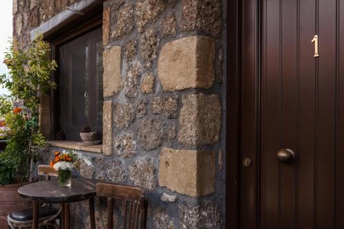 a stone wall with a table and a window at Pera Alonia Guest House in Kato Trikala Korinthias
