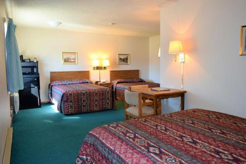 een hotelkamer met twee bedden en een tafel bij Country Inn Libby in Libby