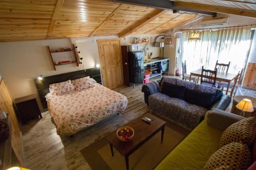 a living room with a bed and a couch at El Paso de las Cigüeñas in Candeleda