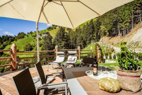 a patio with a table and chairs and an umbrella at Chalet Flierer in Rodengo