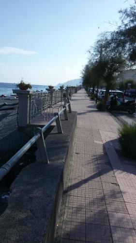 une rangée de bancs sur un trottoir près de l'océan dans l'établissement Casa del pozzo, à Furci Siculo