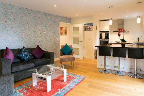 uma sala de estar com um sofá e uma cozinha em Penthouse 5 mins walk to City Centre & Colleges with Balcony & Sleeps 6 em Cambridge