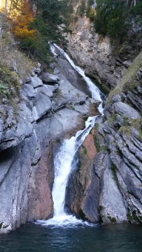 a waterfall on the side of a rocky mountain at Appartments Haus Monika in Schoppernau