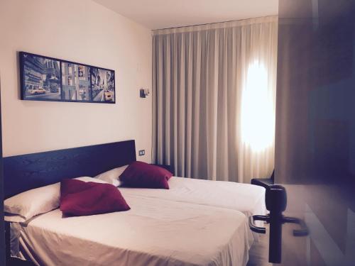 um quarto de hotel com duas camas e uma janela em Torrecobijo em Sangonera La Seca