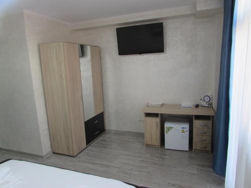a room with a desk and a television on a wall at La Marcu Pensiune in Tulcea