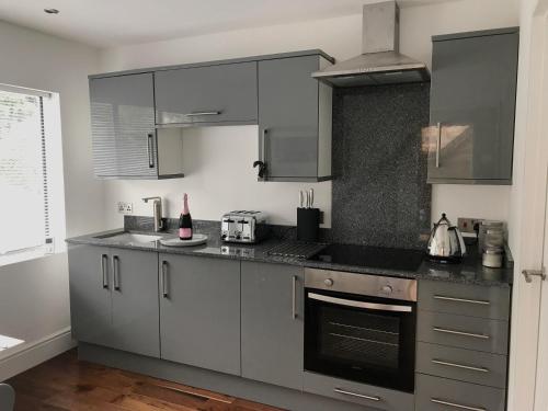 a kitchen with gray cabinets and a stove top oven at Oak-Island Hall in Huntingdon