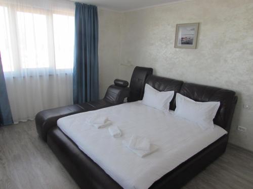 a bedroom with a bed with a leather couch at La Marcu Pensiune in Tulcea
