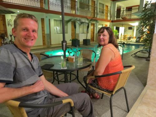 a man and a woman sitting in chairs next to a pool at Hotel Las Flores in Ica
