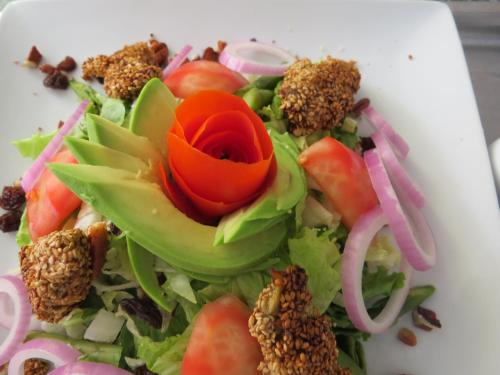 a salad with a red flower on a white plate at Hotel Las Flores in Ica