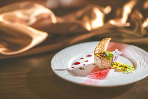 a white plate with a piece of food on a table at Komló Hotel Gyula in Gyula