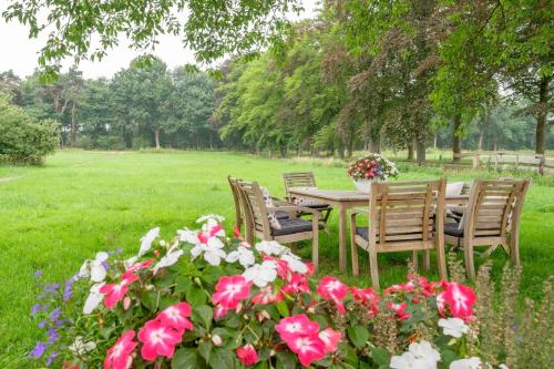 a table and chairs in a field with flowers at B&B Erve ten Dam in Ambt Delden