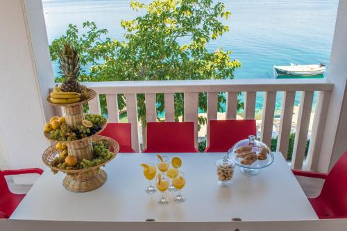 a white table with fruit on top of a balcony at Holiday Home Zdenka in Rogoznica