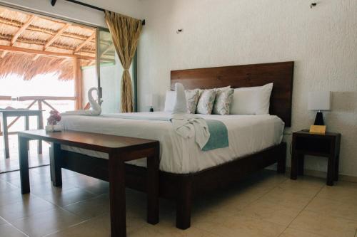 a bedroom with a large bed and a table at Hotel Villa de Pescadores in Río Lagartos