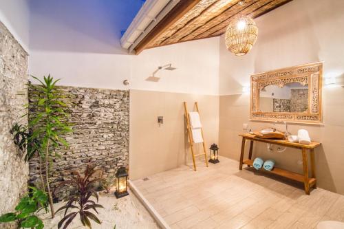 a room with a stone wall and a mirror at Villa Rosa Maldives in Feridhoo