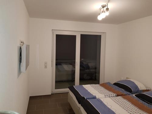 a bedroom with a bed and a sliding glass door at FeWo Lena in Kinderbeuern