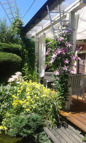a garden with flowers and a bench on a porch at Ranczo w Dolinie Karpia - blisko "Energylandii" Zator in Spytkowice