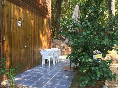 a patio with two chairs and a table and an umbrella at Roatan Bed & Breakfast Apartments in West End