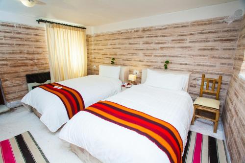 two beds sitting next to each other in a room at Hotel de Sal Luna Salada in Colchani
